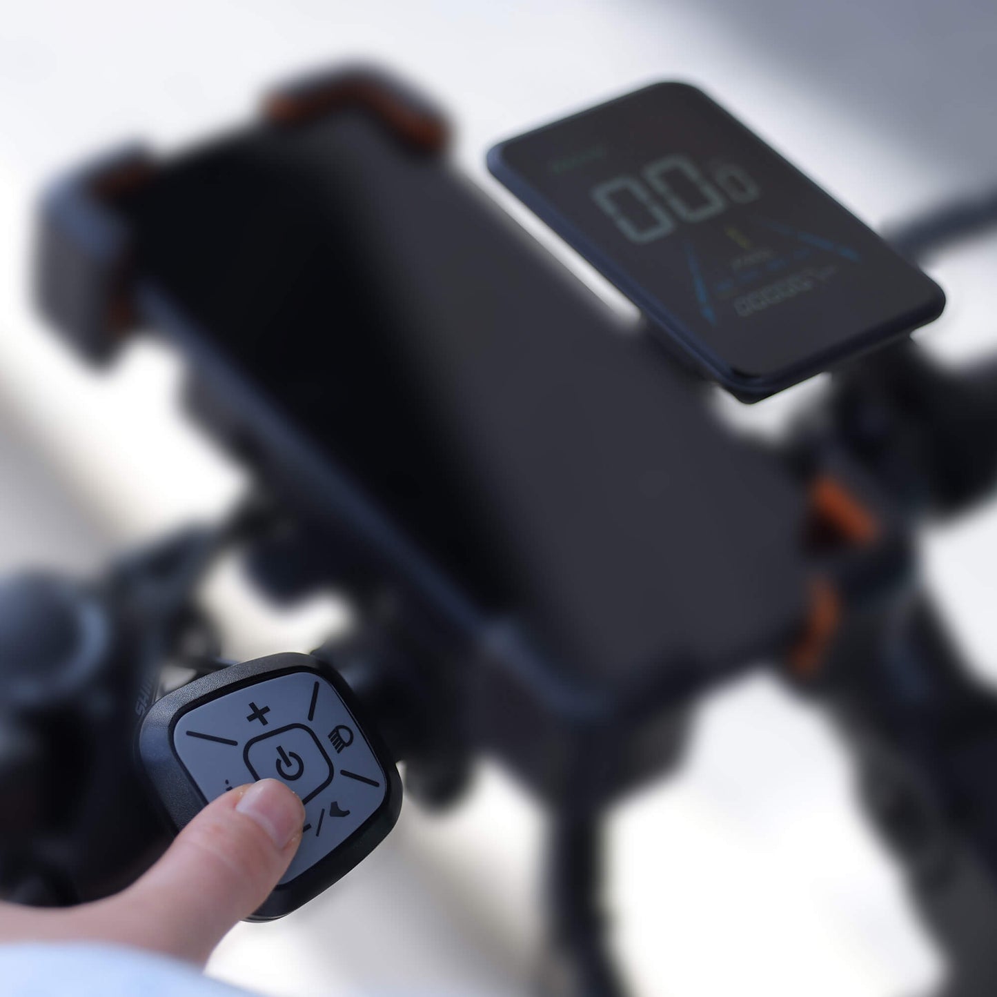 Close-up of a person using a remote control on an electric bike with a blurred background