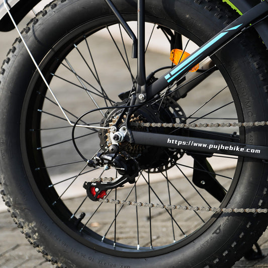Close-up of a electric bicycle wheel with visible branding and chain.