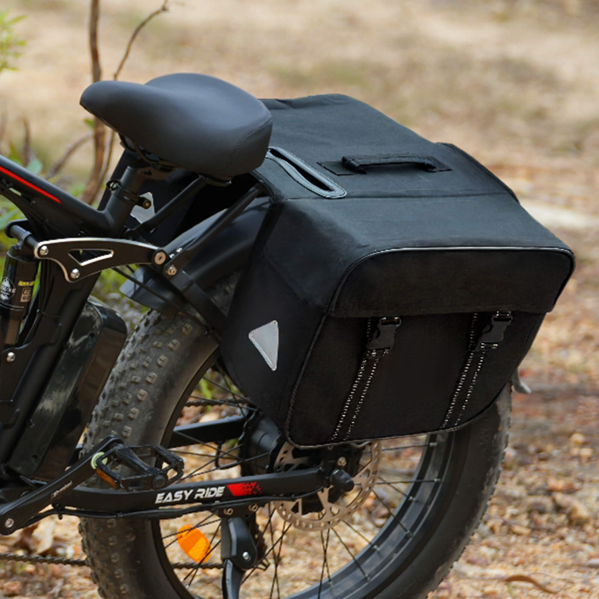 Black bicycle pannier attached to a e-bike with a blurred natural background