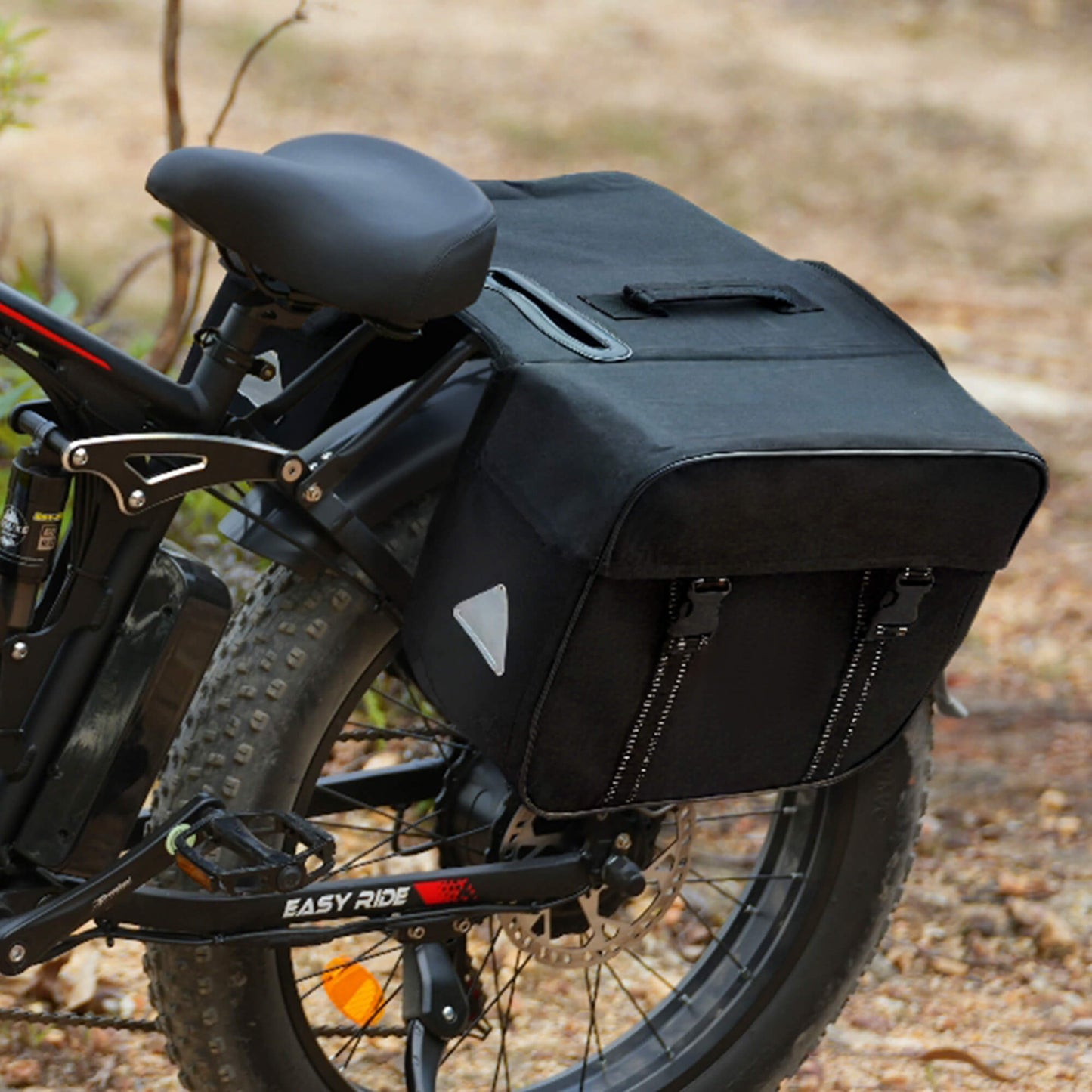Black bicycle pannier attached to a e-bike with a blurred natural background