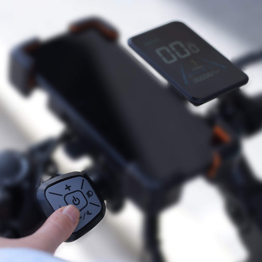 Close-up of a person using a remote control on an electric bike with a blurred background